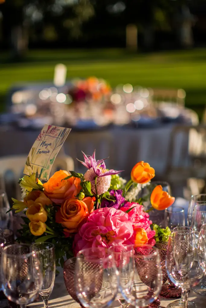 Centro de mesa con rosas naranjas y peonías coral al atardecer