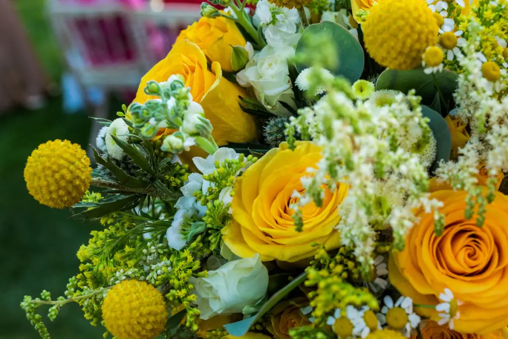 Detalle de rosas amarillas, craspedias y flores blancas