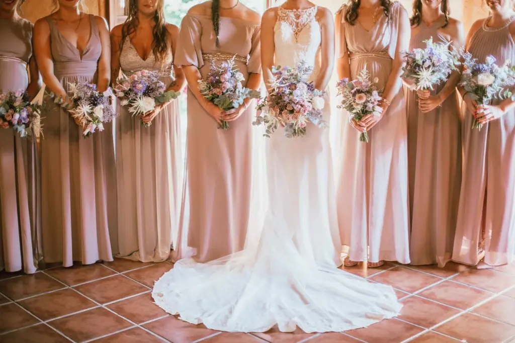 Novia y damas de honor con ramos a juego en tonos lila y rosa