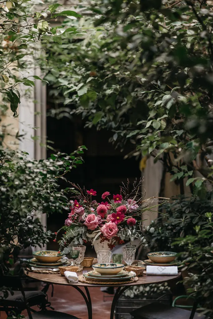Centro de rosas y dalias rosas entre plantas verdes