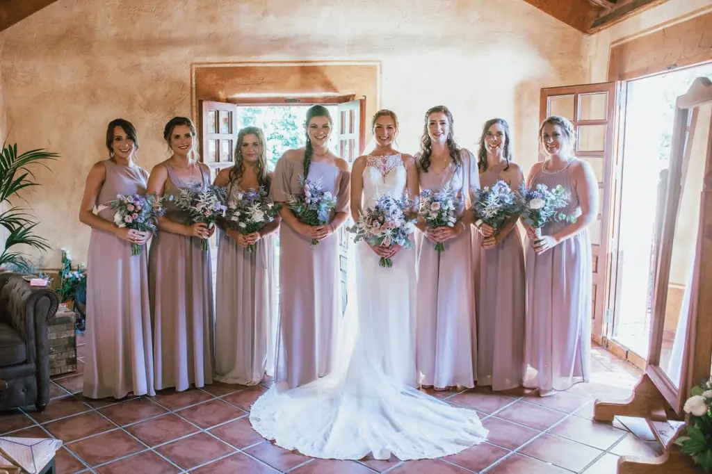 Novia con sus damas de honor vestidas de rosa y ramos de flores silvestres