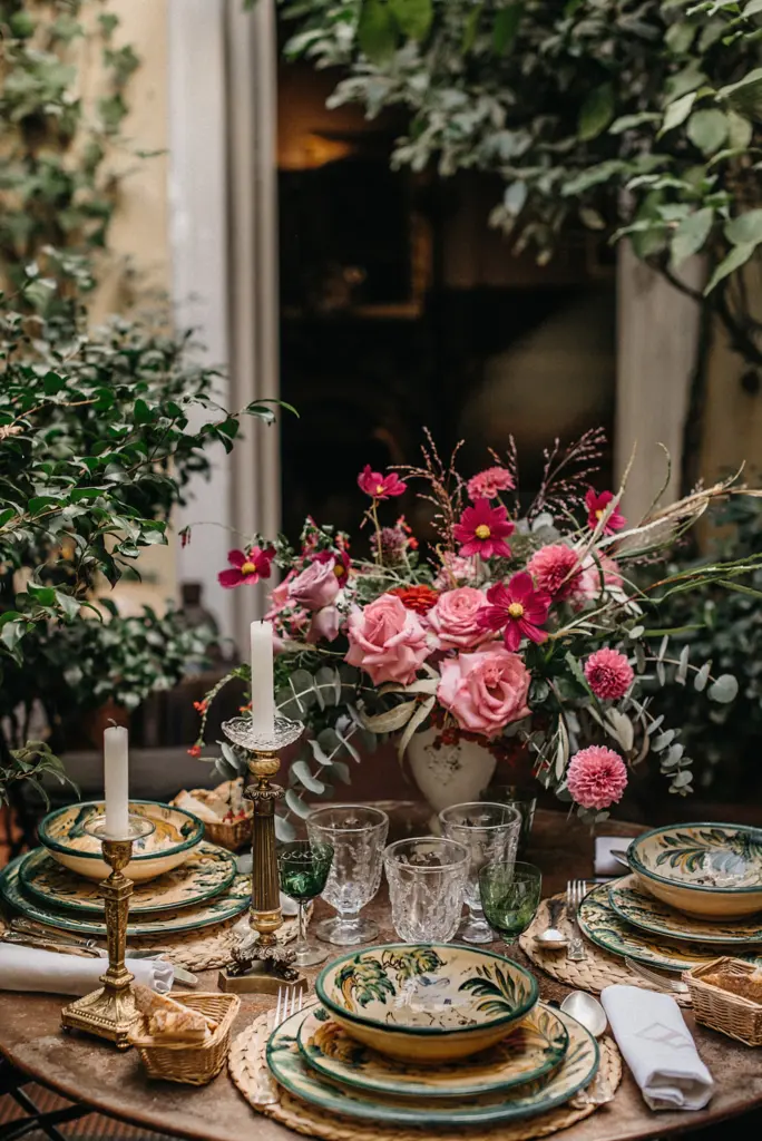 Centro de mesa con rosas y dalias en tonos rosa y fucsia y vajilla de cerámica