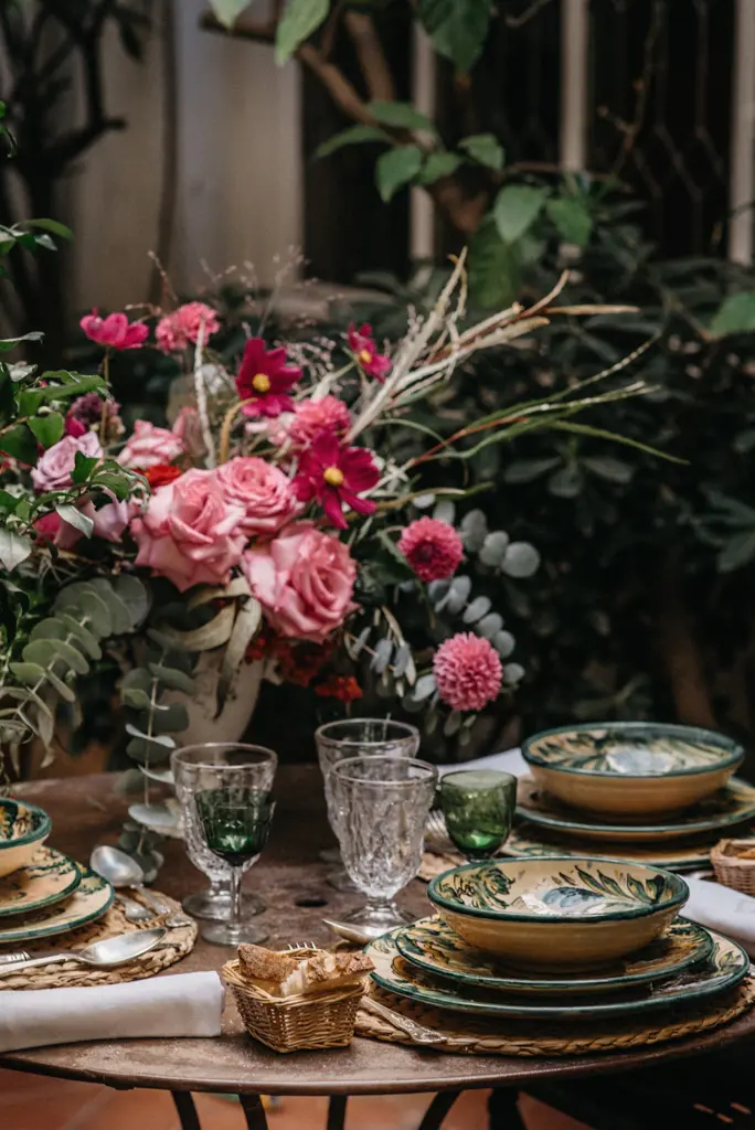 Detalle de un centro de mesa con rosas rosas, dalias y eucalipto