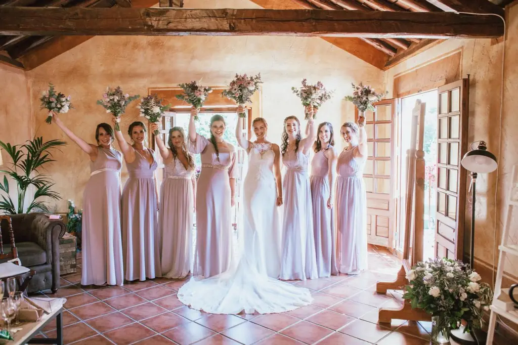 Damas de honor levantando sus ramos junto a la novia