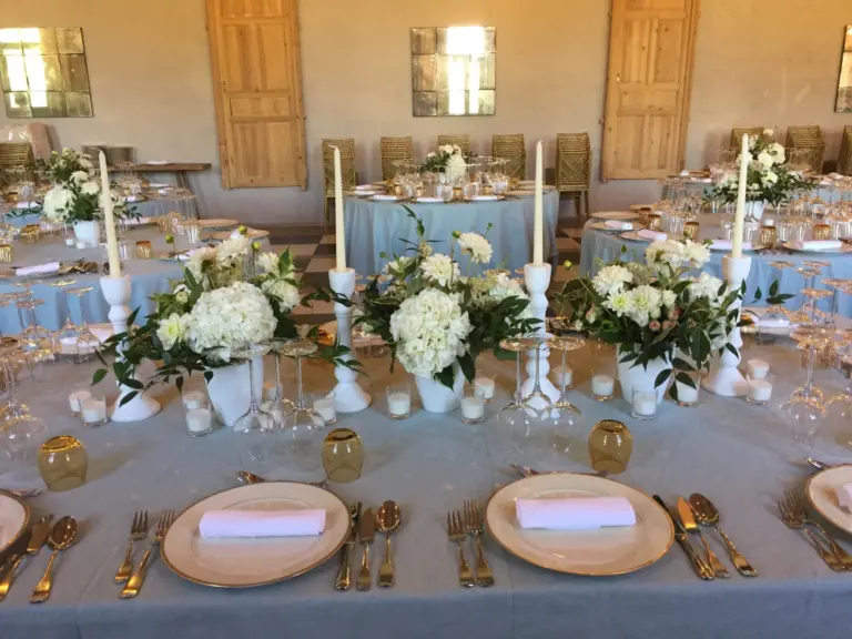 Mesa presidencial con centros de hortensias blancas y candelabros blancos