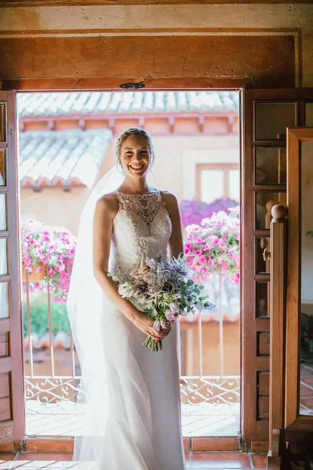 Novia sonriente con un ramo de flores silvestres en tonos lila