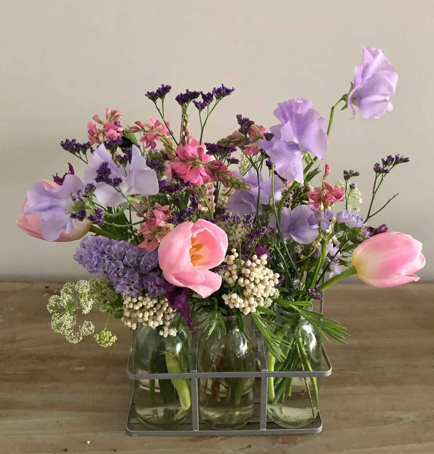 Botellitas de cristal con flores coloridas en tonos alegres