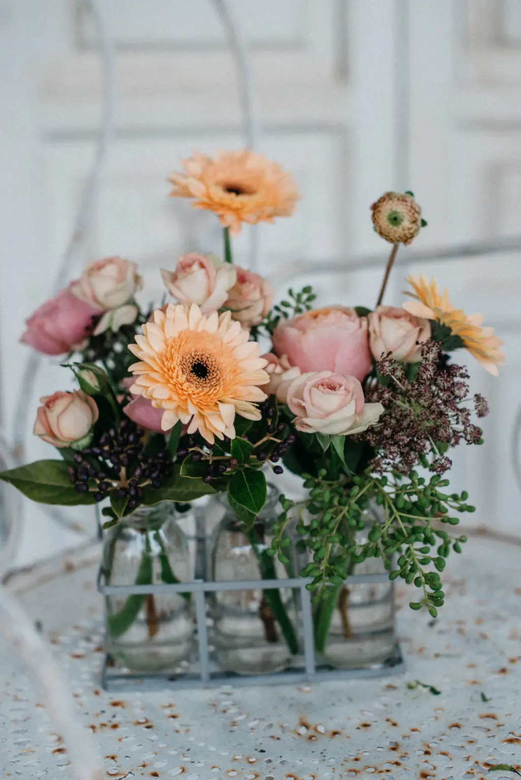 Botellitas de cristal con flores naturales en tonos suaves