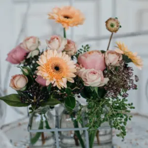 Botellitas de cristal con flores naturales en tonos suaves